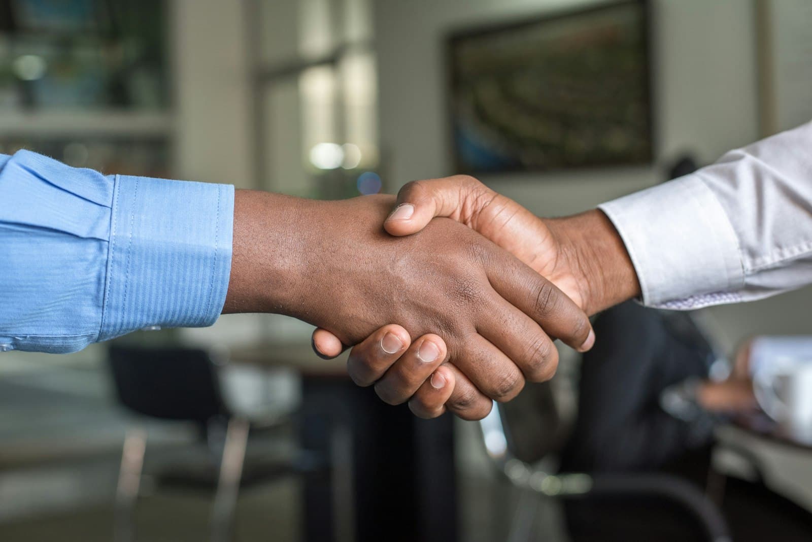 Two professionals shaking hands in a modern law office